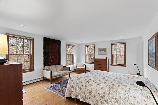 bedroom featuring wood finished floors and a baseboard radiator