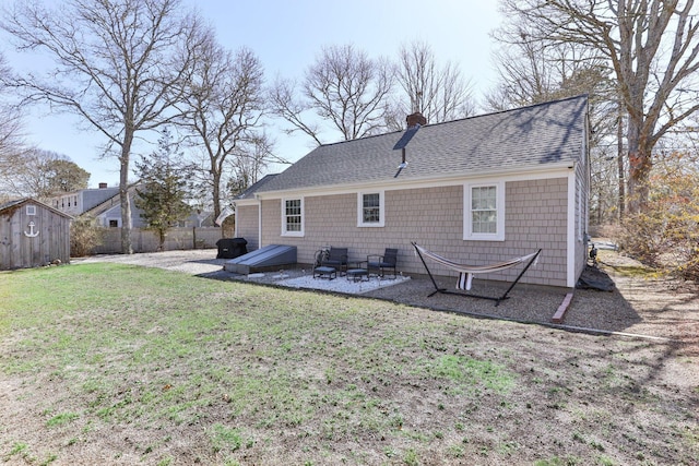 16 Samoset Rd, South Yarmouth, MA 02664 - back of house featuring roof with shingles, a chimney, a patio area, a yard, and fence