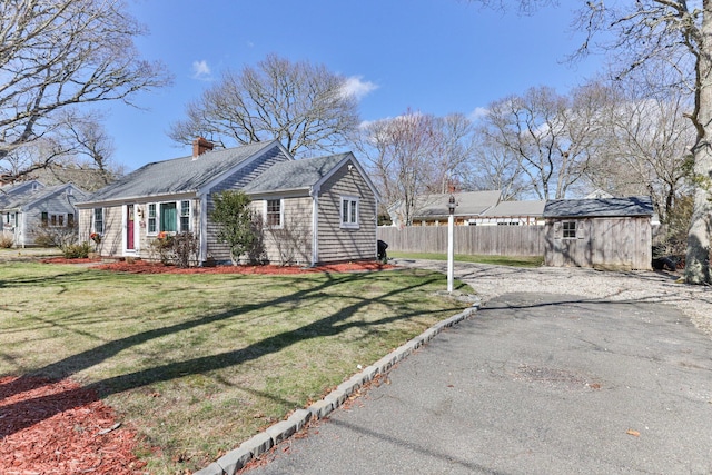 16 Samoset Rd, South Yarmouth, MA 02664 - view of front of home with a chimney, a front lawn, a shed, an outbuilding, and fence