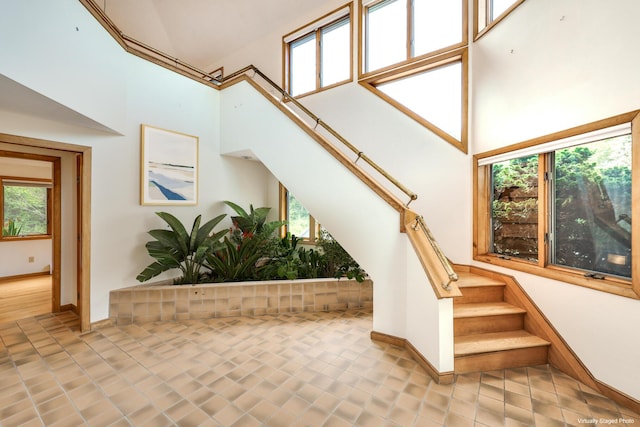 stairs with a high ceiling and tile patterned flooring