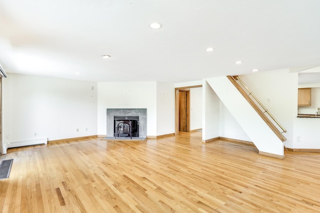 unfurnished living room featuring light hardwood / wood-style floors and baseboard heating