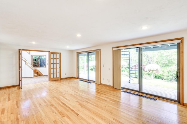 unfurnished living room with light hardwood / wood-style flooring and french doors