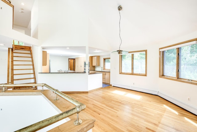 interior space with a towering ceiling, plenty of natural light, and light hardwood / wood-style floors