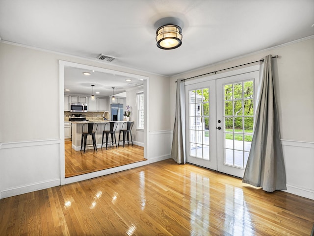 9 Cogswell Path, West Yarmouth, MA 02673 - doorway to outside with french doors, crown molding, light wood-style flooring, baseboards, and a sink