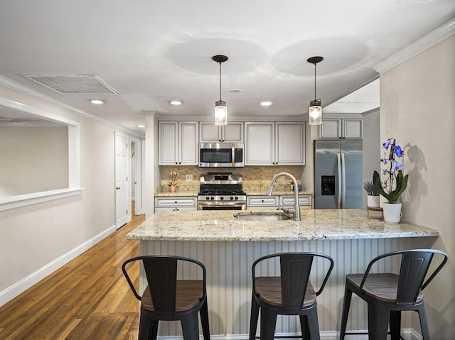 9 Cogswell Path, West Yarmouth, MA 02673 - kitchen featuring appliances with stainless steel finishes, baseboards, a sink, a breakfast bar, and dark wood finished floors