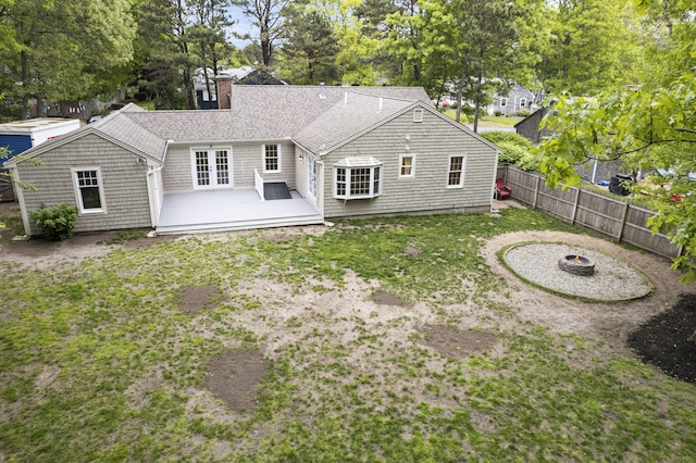 9 Cogswell Path, West Yarmouth, MA 02673 - rear view of property with a fire pit, a chimney, a wooden deck, and view of scattered trees