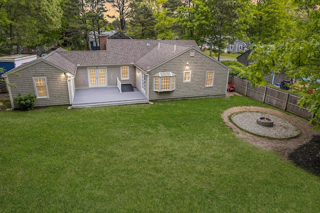 9 Cogswell Path, West Yarmouth, MA 02673 - back of house at dusk with a deck, a chimney, an outdoor fire pit, french doors, and roof with shingles