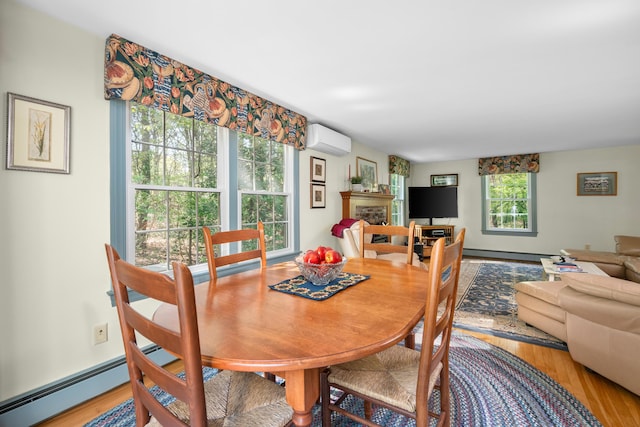 dining space with a wall mounted air conditioner, a fireplace, and light wood-style flooring