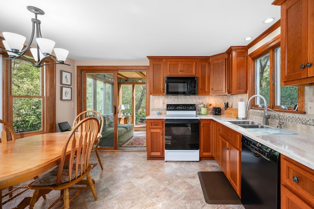 kitchen featuring black appliances, a sink, light countertops, tasteful backsplash, and a chandelier