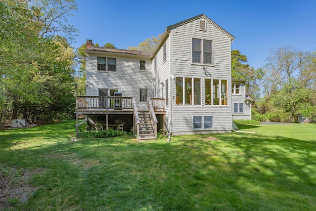 rear view of property featuring stairway, a chimney, a deck, and a lawn