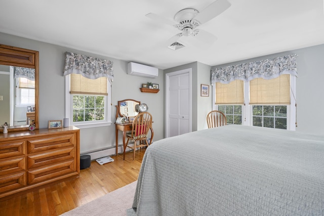 bedroom featuring a wall mounted air conditioner, a baseboard radiator, wood finished floors, ceiling fan, and a baseboard heating unit