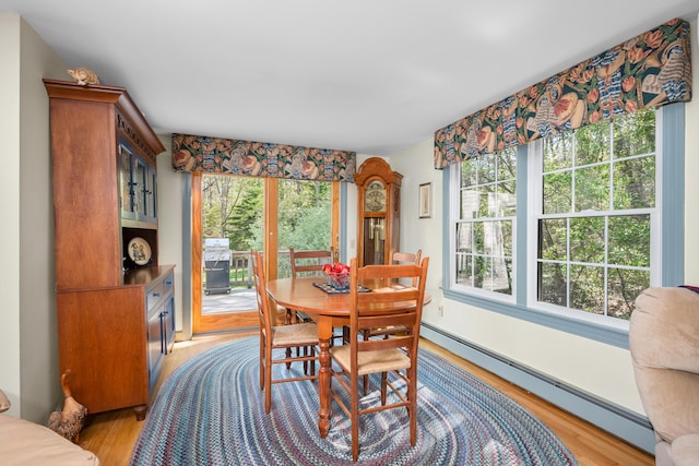 dining area with baseboard heating and light wood-type flooring