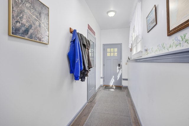 doorway featuring wood finished floors and baseboards