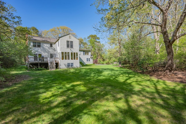 back of property featuring stairway, a deck, and a yard