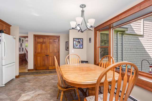 dining area with a chandelier and baseboards
