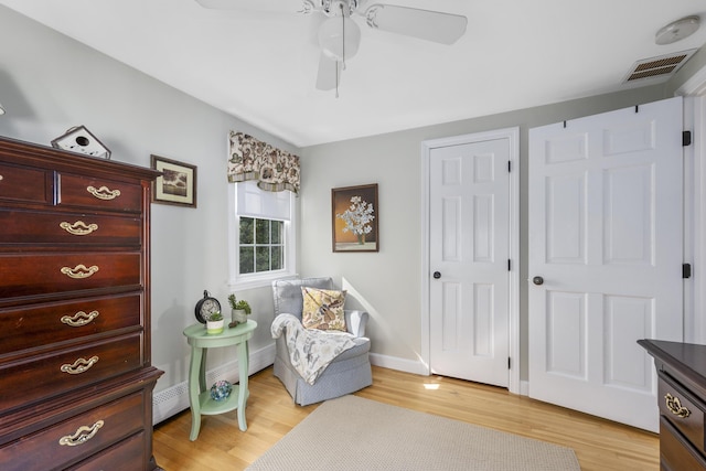 living area featuring light wood-type flooring, ceiling fan, and baseboards