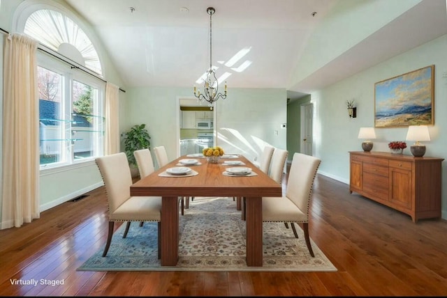 dining space featuring baseboards, visible vents, lofted ceiling, hardwood / wood-style flooring, and a notable chandelier