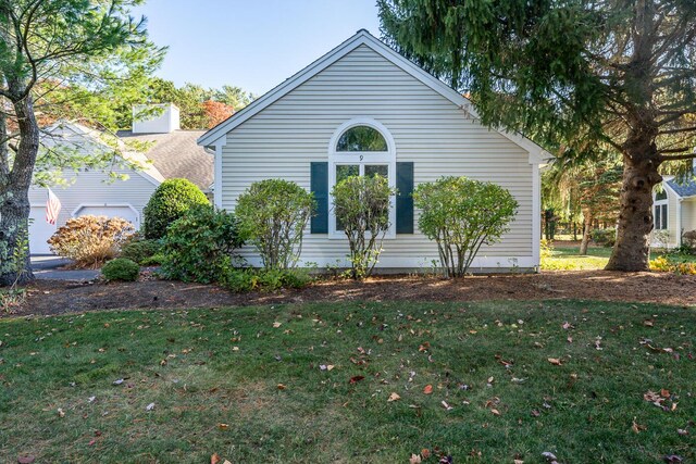 view of side of home with a yard