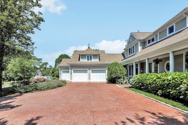 view of front of property with roof with shingles, a garage, and decorative driveway