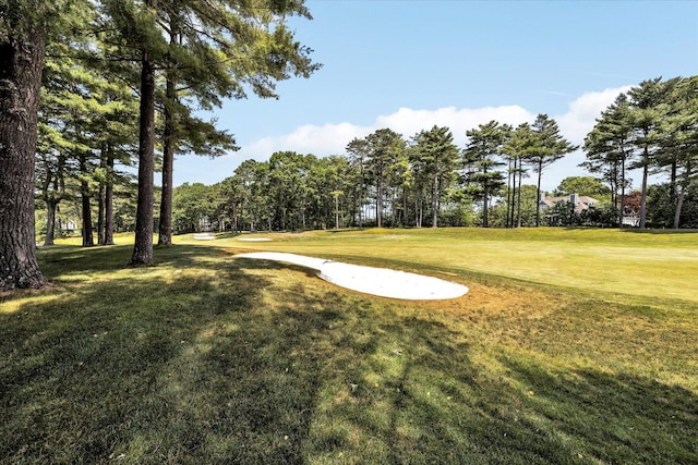 view of community featuring golf course view and a lawn