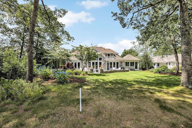 back of property with a sunroom and a yard
