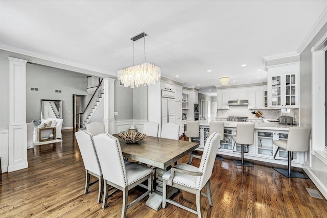 dining area with a chandelier, crown molding, dark wood-style floors, and visible vents