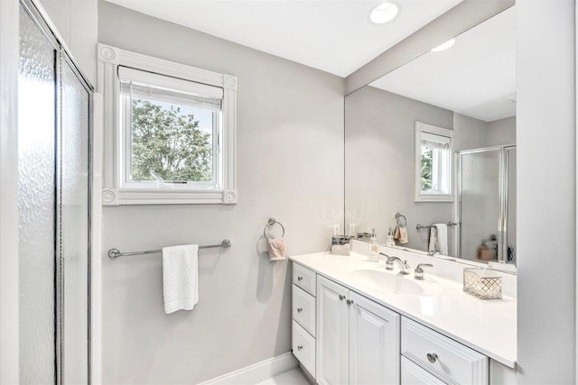 full bathroom with vanity, baseboards, and a stall shower