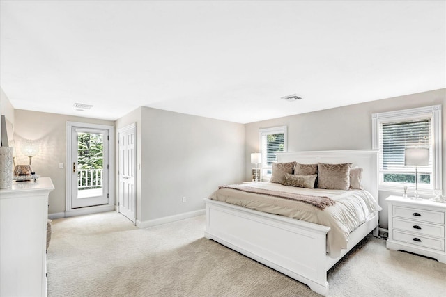 bedroom featuring access to outside, baseboards, multiple windows, and visible vents