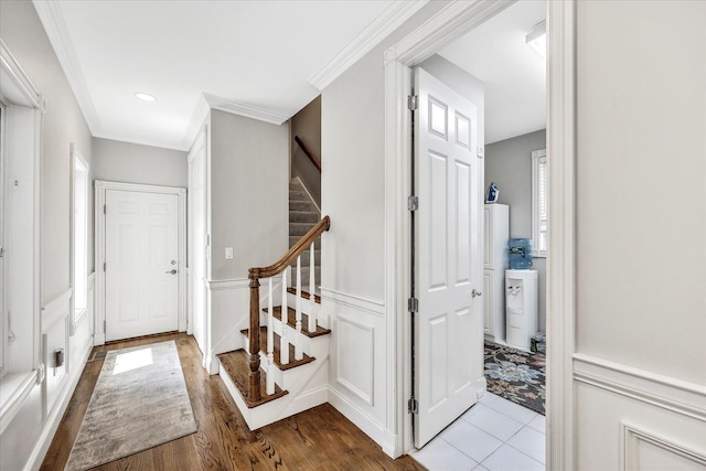 foyer featuring crown molding, recessed lighting, wood finished floors, and stairs