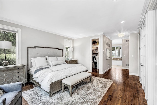 bedroom featuring a closet, baseboards, crown molding, a walk in closet, and wood finished floors