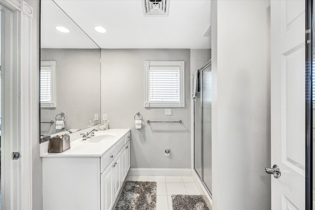 bathroom with vanity, tile patterned flooring, visible vents, a stall shower, and baseboards