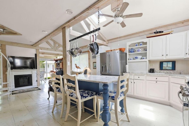 130 Wimbledon Dr, West Yarmouth, MA 02673 - dining area featuring a ceiling fan, vaulted ceiling, light floors, and a glass covered fireplace