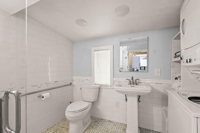 130 Wimbledon Dr, West Yarmouth, MA 02673 - bathroom with stacked washer / drying machine, tile walls, and a wainscoted wall