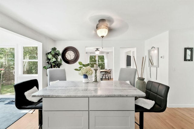 dining area with light wood finished floors and baseboards