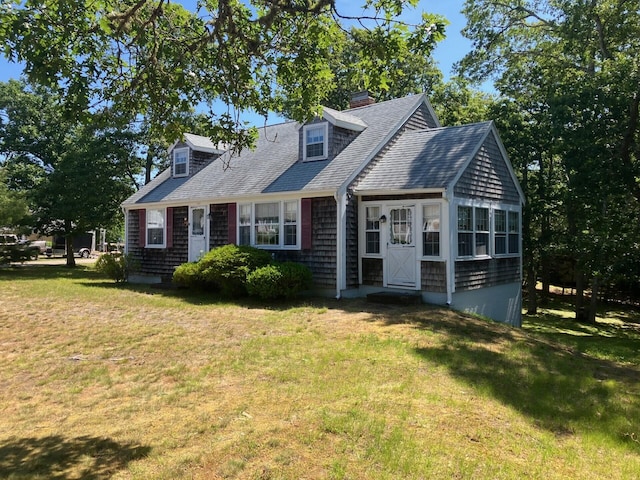 131 Forest Beach Rd, South Chatham, MA 02659 - new england style home featuring a front yard, roof with shingles, and a chimney