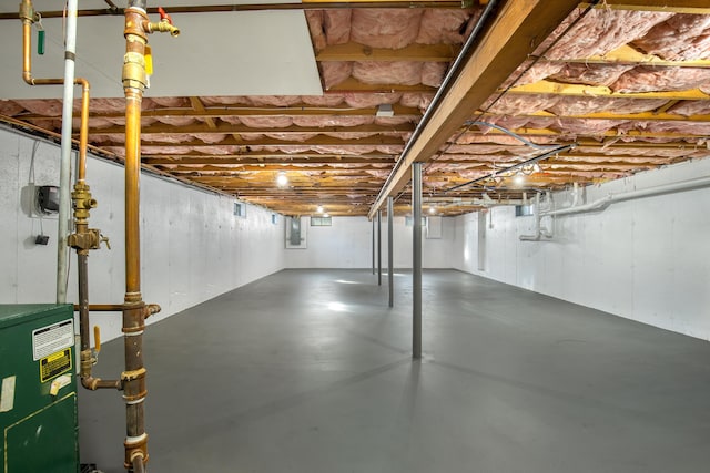 basement featuring electric panel and a heating unit