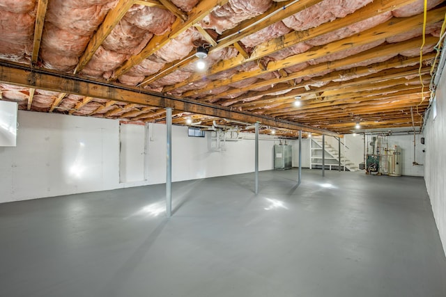 unfinished basement featuring stairs, gas water heater, and water heater