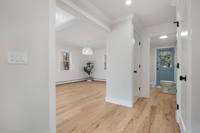 corridor with baseboard heating, light wood-style flooring, baseboards, and ornamental molding