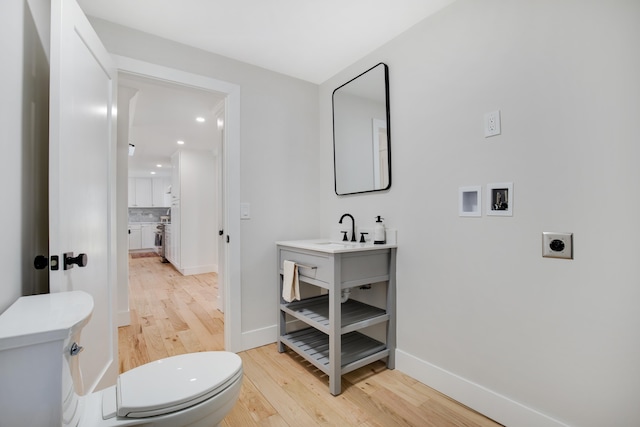 half bath featuring backsplash, toilet, baseboards, and wood finished floors