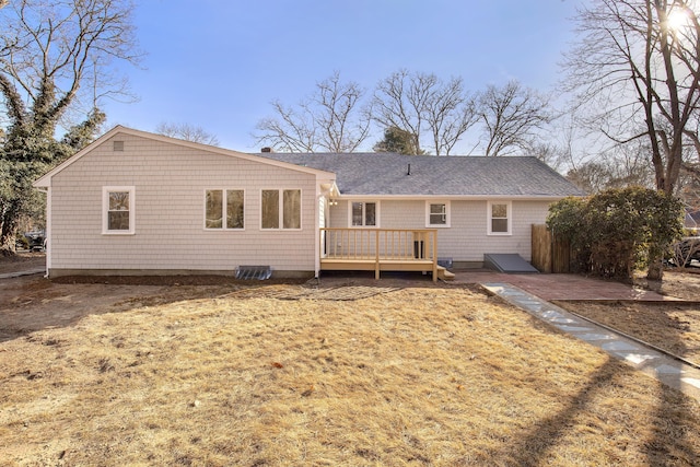 rear view of property with a wooden deck and roof with shingles