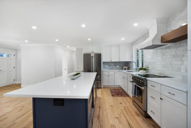 kitchen with custom exhaust hood, appliances with stainless steel finishes, a center island, and light countertops