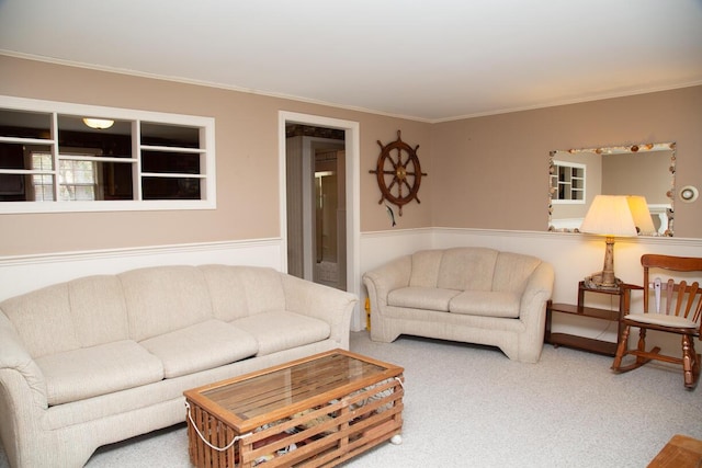 living room featuring wainscoting, crown molding, and carpet floors