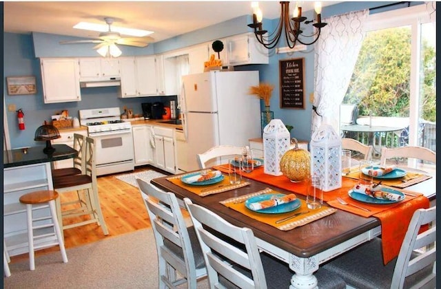 4 Coffey Ln, Dennis Port, MA 02639 - kitchen with white appliances, under cabinet range hood, a chandelier, and white cabinetry