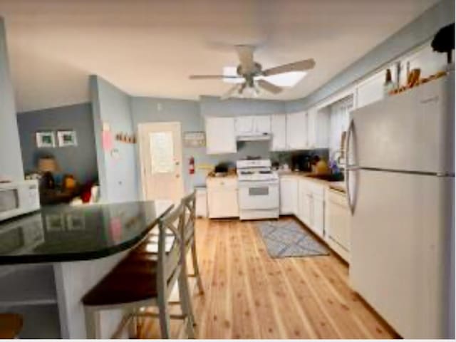 4 Coffey Ln, Dennis Port, MA 02639 - kitchen with white appliances, white cabinets, a ceiling fan, extractor fan, and light wood-style flooring