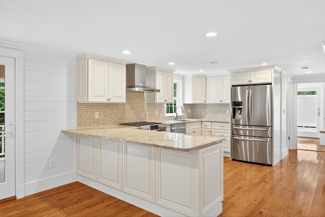 28 Stoney Cliff Rd, Centerville, MA 02632 - kitchen with appliances with stainless steel finishes, wall chimney range hood, a peninsula, light stone countertops, and backsplash