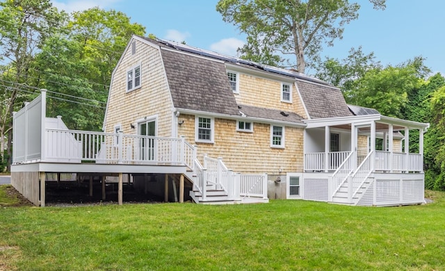 28 Stoney Cliff Rd, Centerville, MA 02632 - back of property with stairway, roof with shingles, and a lawn