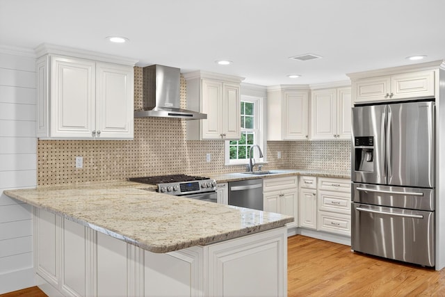 28 Stoney Cliff Rd, Centerville, MA 02632 - kitchen featuring appliances with stainless steel finishes, wall chimney range hood, a peninsula, white cabinetry, and light stone counters