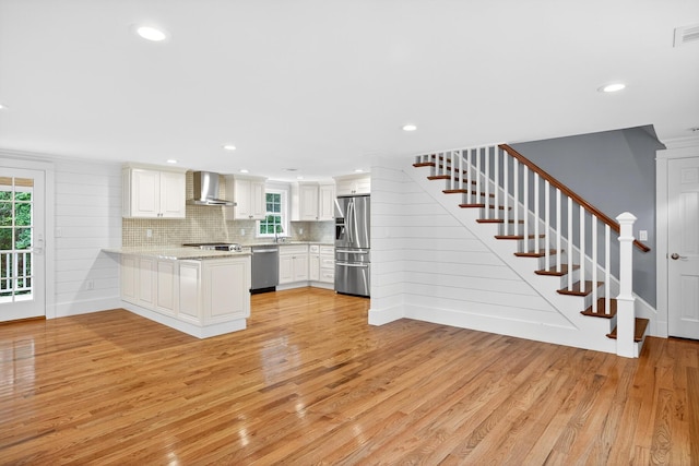 28 Stoney Cliff Rd, Centerville, MA 02632 - kitchen featuring wall chimney exhaust hood, stainless steel appliances, light wood-style floors, white cabinetry, and recessed lighting