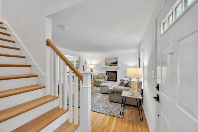 13 Pickerel Way, Forestdale, MA 02644 - living area featuring a glass covered fireplace, stairs, wood finished floors, and baseboards