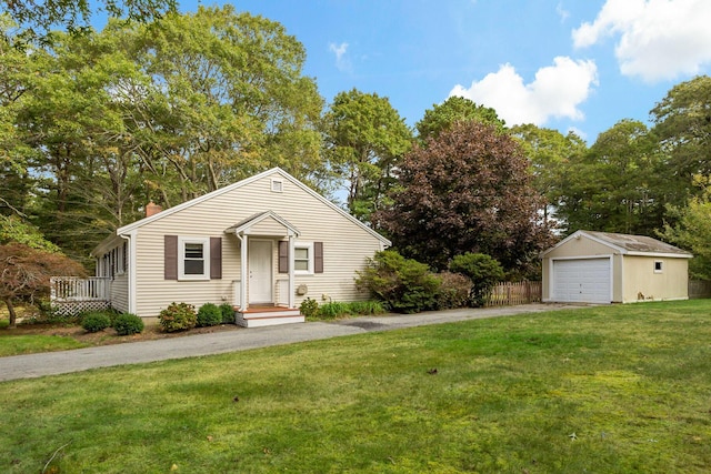 view of front of property with a garage, a front yard, and an outdoor structure